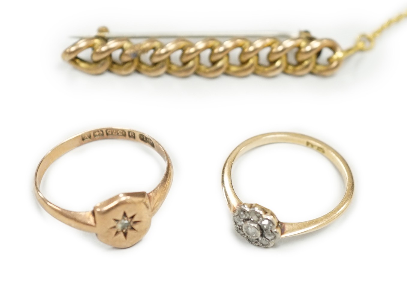 A small 18ct and diamond set cluster ring, size K, gross 1.2 grams, a 9ct gold and diamond chip set ring and a yellow metal curb link bar brooch, gross 5.1 grams.
